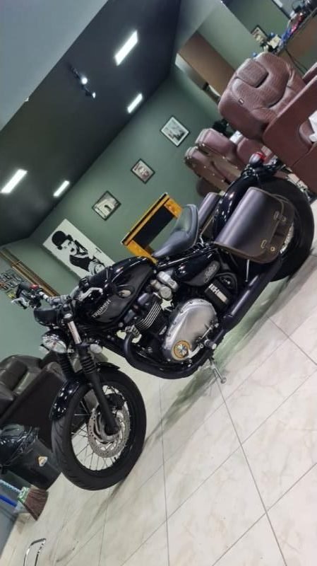 Moto Triumph exposta dentro da barbearia